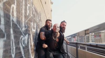 La estrella de AEW Darby Allin siendo retenida por dos guardias de seguridad